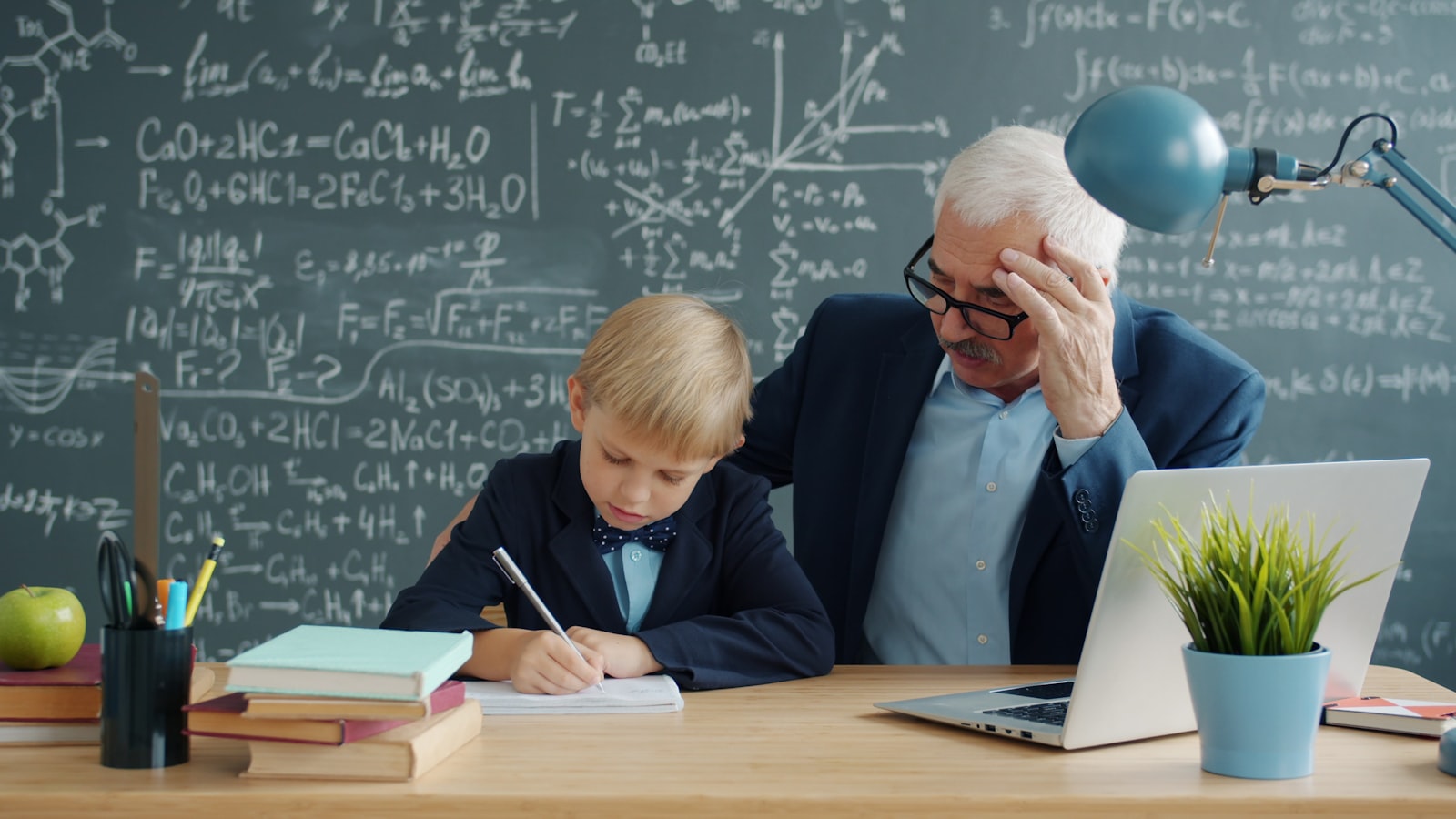 Teacher writing chatgpt prompts for grammar lessons on a laptop while planning class material