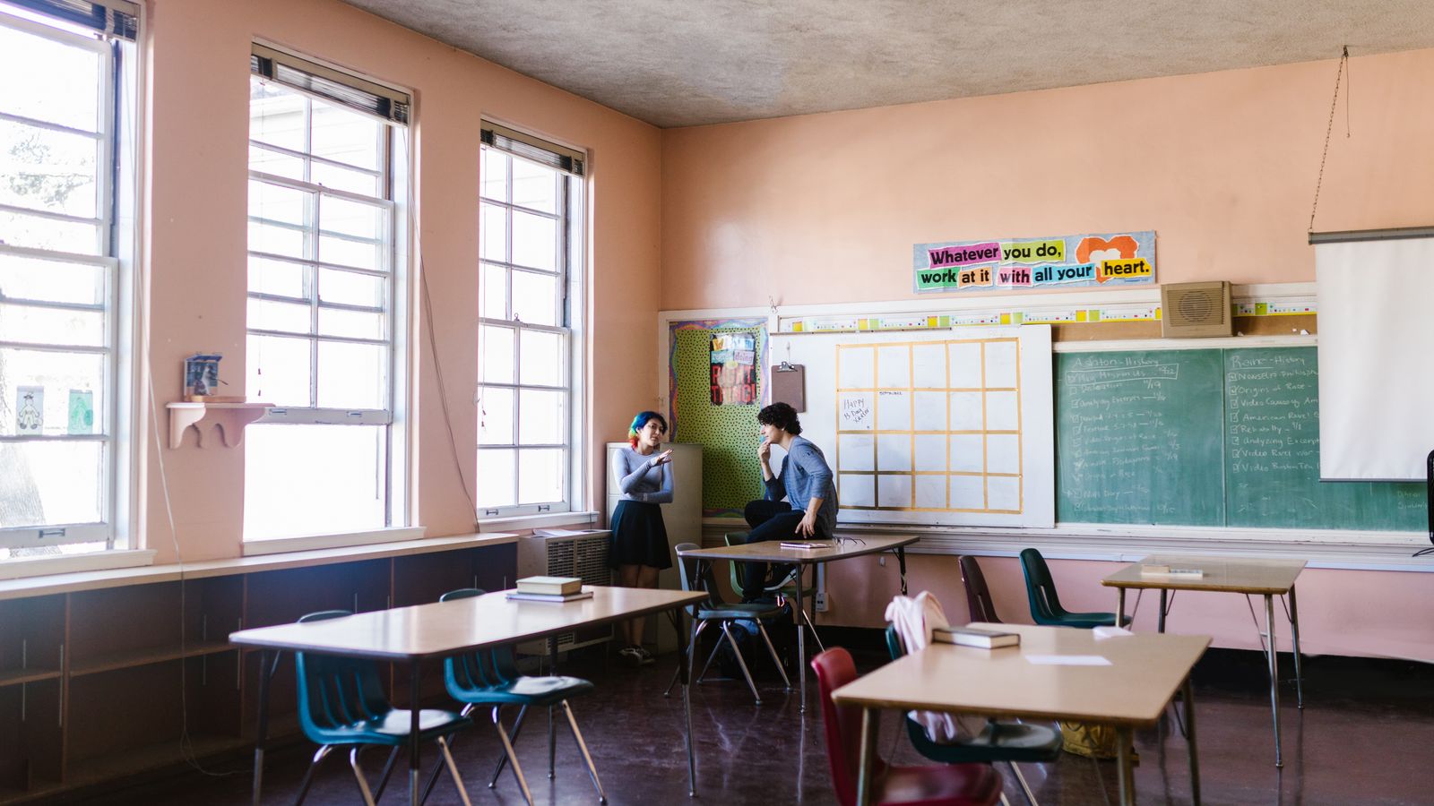 Two ESL students practicing a speaking dialogue in a classroom using an AI dialogue generator