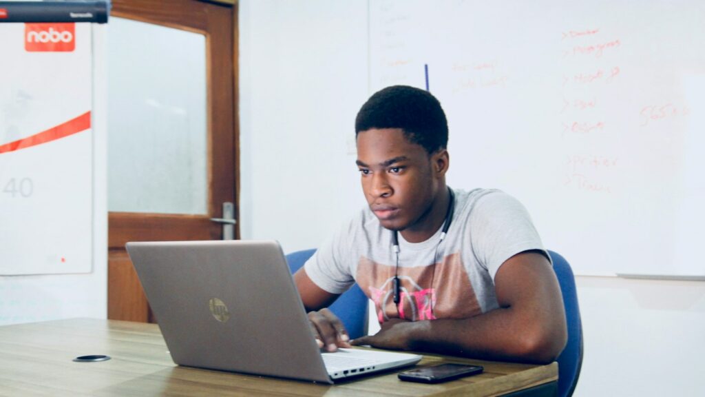 Teacher at a laptop adapting teaching materials to a lower English level