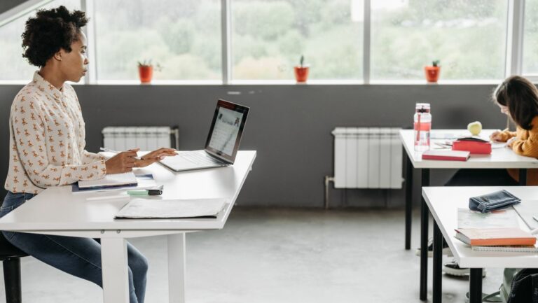 English teacher using AI in English language teaching to plan a lesson on her laptop