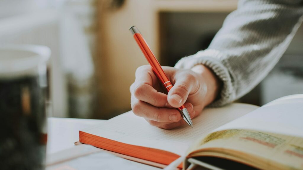 English learner writing an essay by hand before receiving AI generated writing feedback