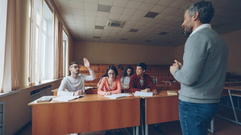 English teacher eliciting answers as a student raises his hand in class