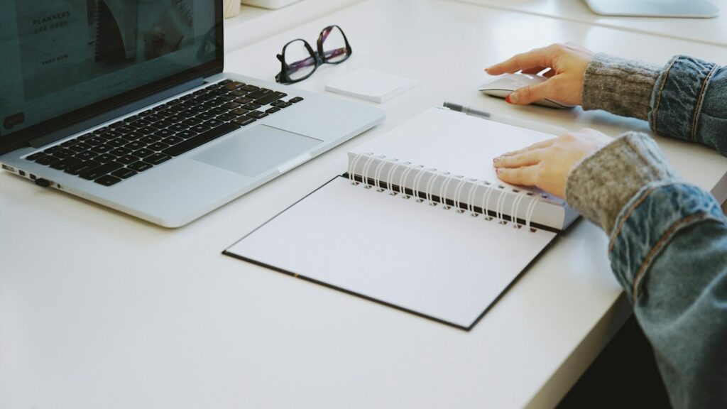Teacher pausing over a blank notebook while planning a lesson with AI help
