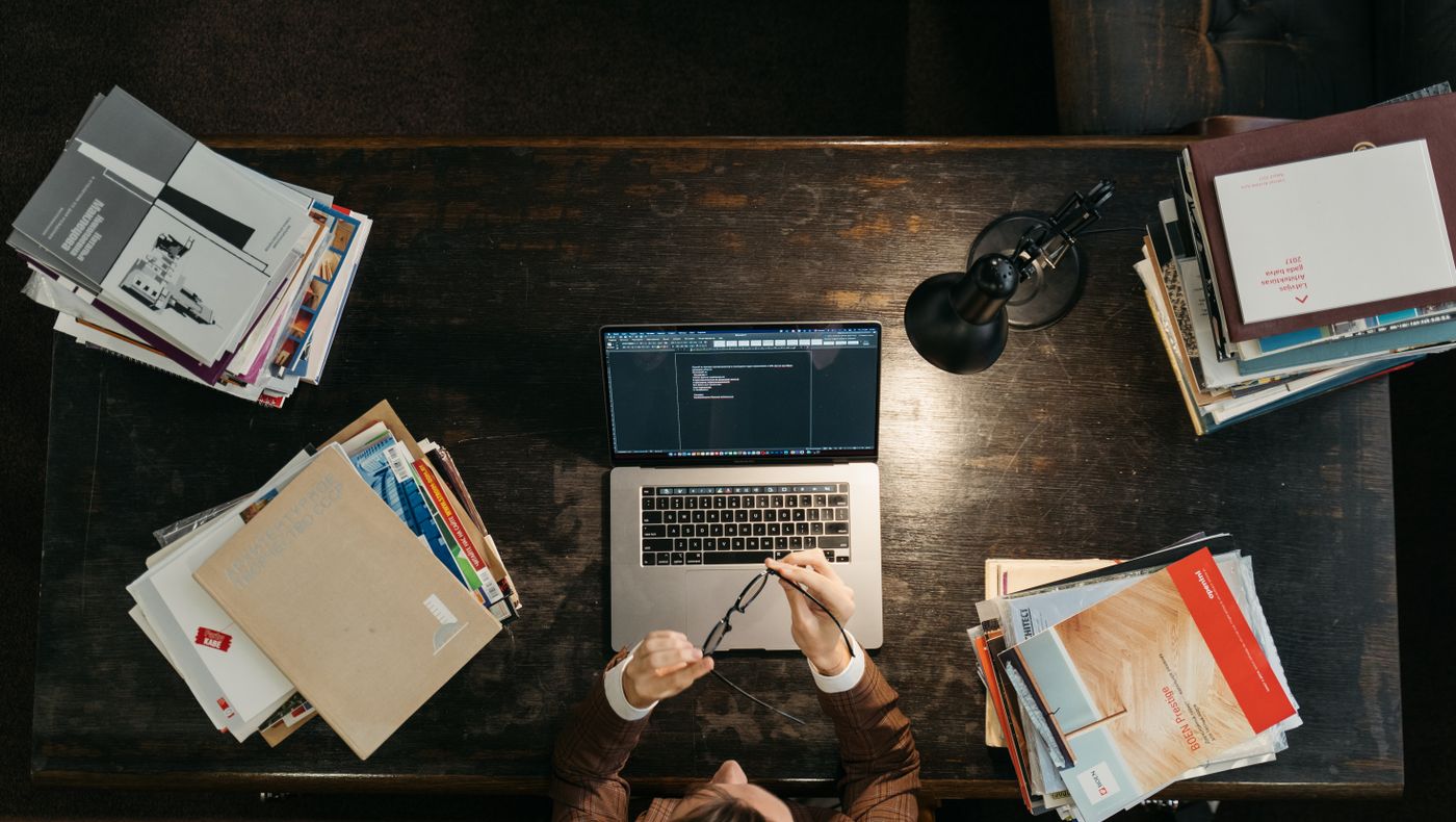 Desk with books and a laptop set up for planning English lessons with AI