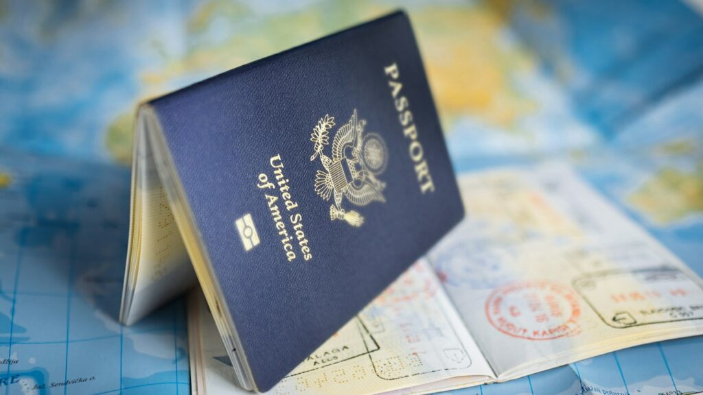 Passport lying open on a world map showing where you can teach English abroad
